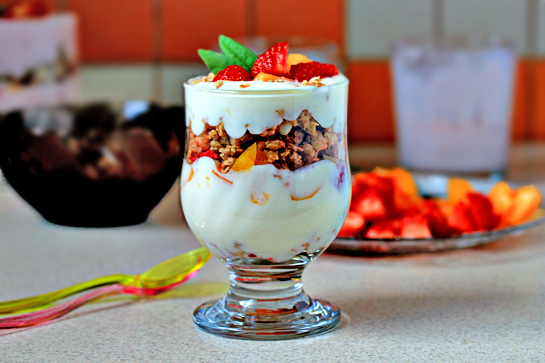 fruit yogurt parfaits recipe with step by step pictures, line up four glasses or parfait goblets, layer spoonfuls of granola, yogurt, and fruit until the glasses are full, place some fruit on top