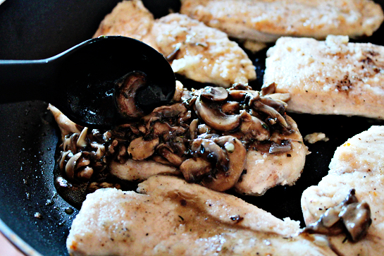 chicken with mushrooms and cheese step by step recipe with ingredients and pictures, spooning mushroom sauce over cooked chicken breast fillets in a large frying pan