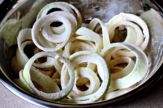 oven-fried onion rings with potato chips coating, recipe with step by step pictures, onion rings covered with flour mixture in a stainless steel bowl