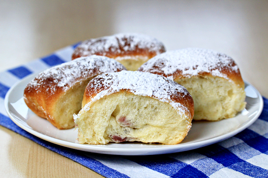 sweet jam filled buns on a plate dusted with sugar