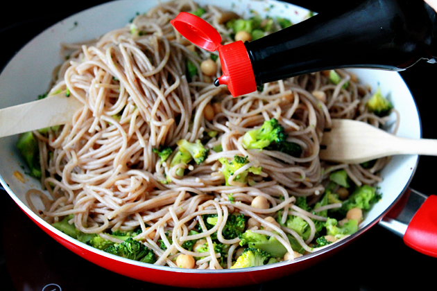 broccoli, chickpeas and garlic whole wheat spaghetti recipe, combining and drizzling with soy sauce
