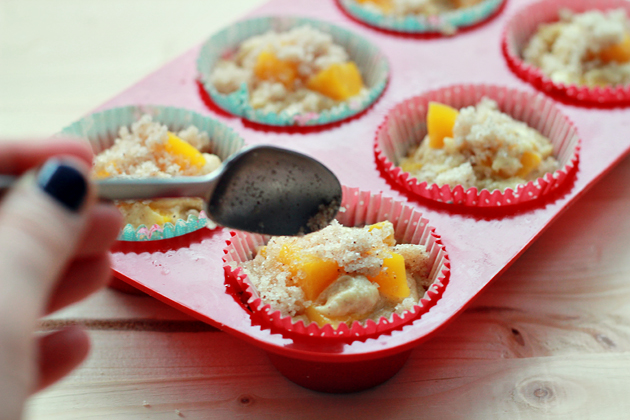adding streusel topping on top of peach cobbler muffins